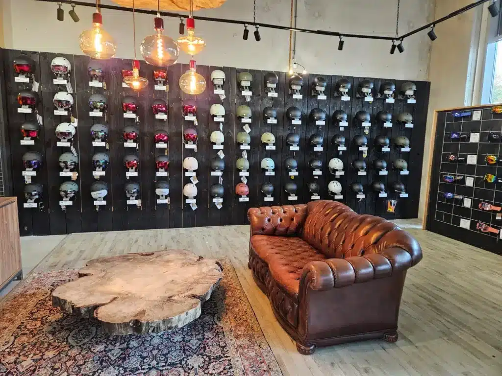 De showroom van 2ndride.nl met een wand vol tweedehands skihelmen
